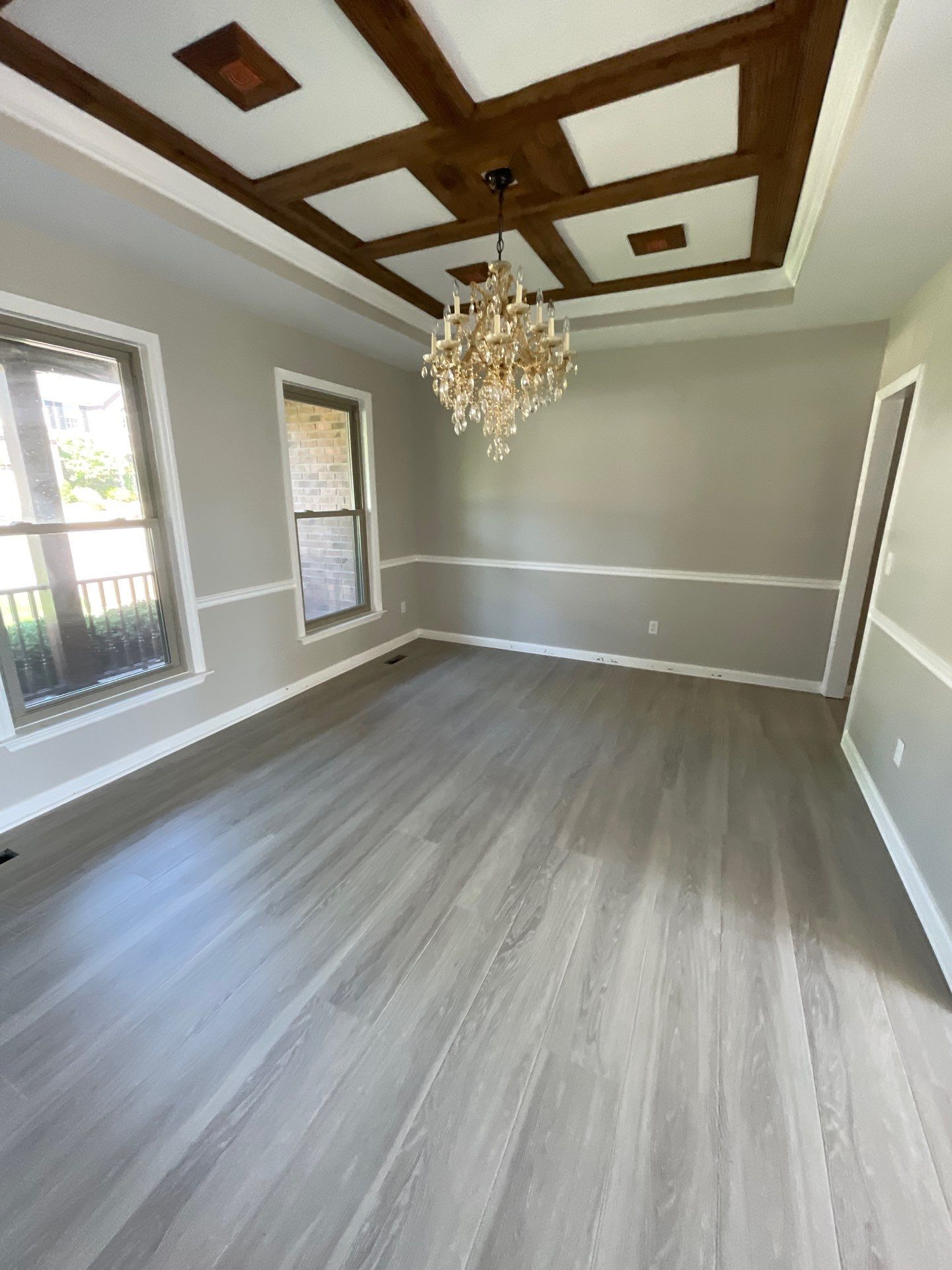Finished dining room with custom stained coffered ceiling beams and chandelier after IRS reconstruction